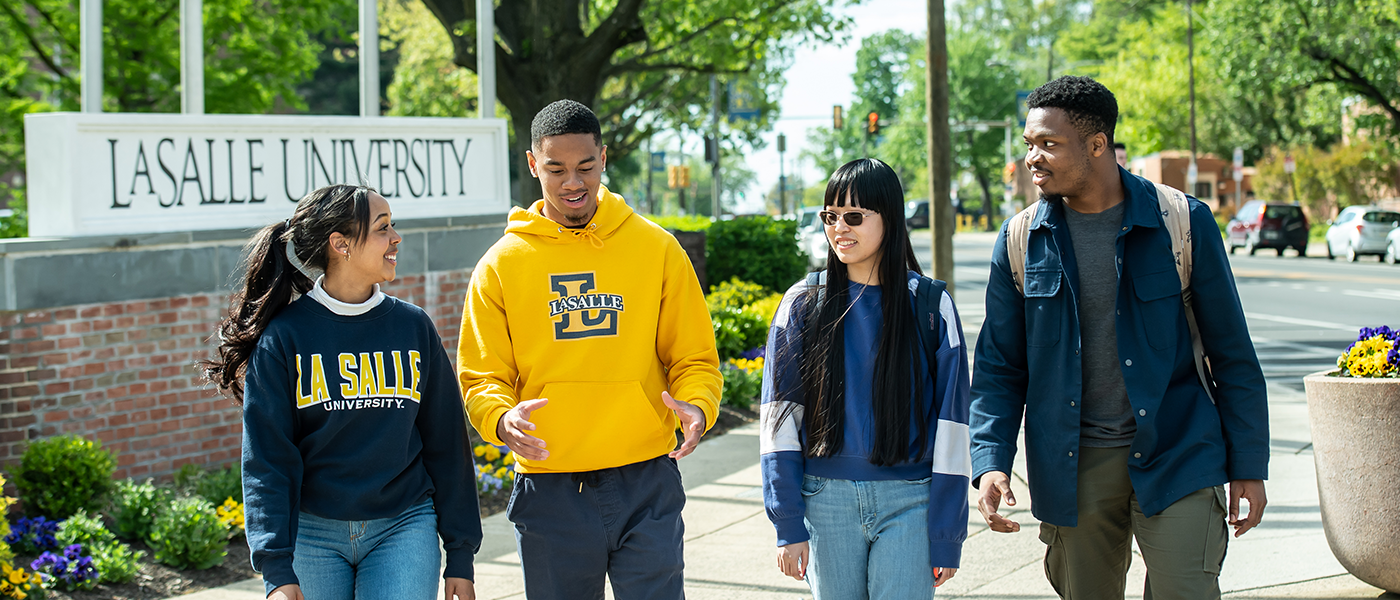 Image of four students walking around ɫƵ's campus.