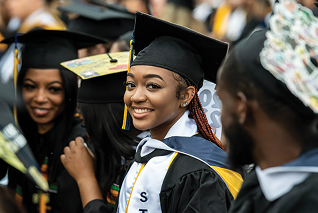 Image of a female student smiling at the camera during Commencement.